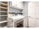 Well-organized laundry room featuring modern white washer and dryer with built-in shelves at 320 E 86Th St, Indianapolis, IN 46240