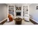 Inviting living room featuring a fireplace with white surround flanked by built-in shelving and hardwood floors at 320 E 86Th St, Indianapolis, IN 46240