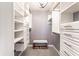 Spacious walk-in closet with custom shelving, drawers, and a bench for organized storage at 320 E 86Th St, Indianapolis, IN 46240