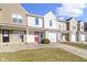 Inviting townhouse with a red front door, attached garage, and well-maintained landscaping on a sunny day at 459 Dekalb Dr, Westfield, IN 46074