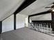 Attic space with carpet floors, wood paneling, black support beams, and railing that leads to a stairwell at 4953 Mccray St, Indianapolis, IN 46224