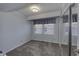 Bedroom with pale blue walls, carpet, large window, and mirrored closet doors at 4953 Mccray St, Indianapolis, IN 46224