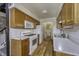 Galley kitchen featuring white appliances, light wood cabinetry, and hardwood floors at 4953 Mccray St, Indianapolis, IN 46224