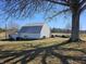 Well-maintained barn with white siding, a lean-to, and a covered parking area on a grassy lot at 5420 W Goeller W Rd, Columbus, IN 47201