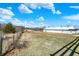 Acreage featuring fenced pasture, a large barn structure, and a backdrop of mature trees, ideal for livestock or storage at 5420 W Goeller W Rd, Columbus, IN 47201