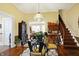 Cozy dining room featuring hardwood floors and a glass table adjacent to the staircase at 5420 W Goeller W Rd, Columbus, IN 47201