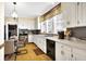 Bright kitchen featuring white cabinetry, countertops, and an adjacent dining area with glass table at 5420 W Goeller W Rd, Columbus, IN 47201