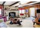Rustic living room featuring a stone fireplace, wood paneling, and exposed beams at 5420 W Goeller W Rd, Columbus, IN 47201