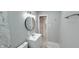Clean bathroom featuring a modern vanity, round mirror, and tile accents for a stylish look at 5546 Marilyn Rd, Indianapolis, IN 46226