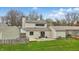 Landscaped backyard with wood deck, a glass sunroom, and sliding glass doors at 5762 Overcrest Dr, Indianapolis, IN 46237