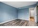 Bright, empty bedroom with blue walls, wood floors and white trim at 5762 Overcrest Dr, Indianapolis, IN 46237