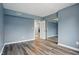 Spacious bedroom with wood flooring, light blue walls and a mirrored closet at 5762 Overcrest Dr, Indianapolis, IN 46237
