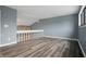 This bedroom overlooks the living area and features neutral paint and wood-look flooring at 5762 Overcrest Dr, Indianapolis, IN 46237