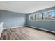 This bedroom has wood-look floors, neutral walls, and large windows letting in natural light at 5762 Overcrest Dr, Indianapolis, IN 46237