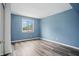 Blue bedroom featuring a large window and wood-look flooring at 5762 Overcrest Dr, Indianapolis, IN 46237