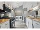 Remodeled kitchen showcasing stainless appliances and adjoining laundry area at 5762 Overcrest Dr, Indianapolis, IN 46237