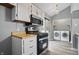 Renovated kitchen offers modern stainless steel appliances and convenient laundry area at 5762 Overcrest Dr, Indianapolis, IN 46237