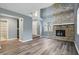 Cozy living room boasting a stone fireplace, luxury vinyl plank flooring and neutral paint at 5762 Overcrest Dr, Indianapolis, IN 46237