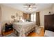 Calm bedroom featuring a ceiling fan, large window, wood floors, and neutral tones, creating a relaxing atmosphere at 6225 Indianola Ave, Indianapolis, IN 46220
