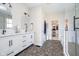 Bathroom with dual vanities, shiplap accent wall, and access to a walk-in closet at 6459 Canak Dr, Avon, IN 46123