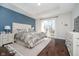 Bright bedroom features a tufted headboard, blue accent wall, and access to a deck at 6459 Canak Dr, Avon, IN 46123