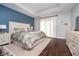 Bright bedroom features a tufted headboard, blue accent wall, and hardwood floors at 6459 Canak Dr, Avon, IN 46123