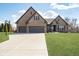 Stunning brick home featuring an attached three-car garage and a well manicured front yard at 6459 Canak Dr, Avon, IN 46123