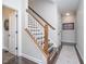 Hallway with staircase, wood railing, and a neutral-colored rug runner at 6459 Canak Dr, Avon, IN 46123