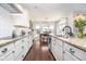 Galley kitchen with white cabinets, granite countertops, subway tile backsplash, and dining area view at 6459 Canak Dr, Avon, IN 46123
