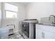 Functional laundry room with modern washer and dryer, tiled floor, and a utility sink at 6459 Canak Dr, Avon, IN 46123