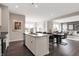 Open kitchen with stainless steel appliances, island seating, and views into the dining and living areas at 7397 Standish Ln, Avon, IN 46123