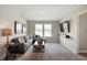 Bright living room with large windows, gray sofa, and entertainment area at 7397 Standish Ln, Avon, IN 46123