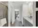 Bright bathroom boasts a double vanity with gray cabinets and a tiled walk-in shower at 7516 Fallsworth Dr, Avon, IN 46123