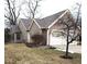 Side view of a house featuring a well-maintained lawn and a two car garage at 7682 Micawber Ct, Indianapolis, IN 46256