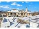 Backyard featuring patio furniture and a partially snow covered brick home under a blue sky at 8329 Hill Gail Dr, Indianapolis, IN 46217