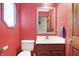 Bathroom with a sink, toilet, mirror, and unique corner window at 8329 Hill Gail Dr, Indianapolis, IN 46217