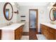 Bathroom featuring dual sinks, a herringbone floor, and a separate toilet area at 8329 Hill Gail Dr, Indianapolis, IN 46217