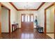 Inviting foyer with wood-look tile flooring, decorative trim, elegant chandelier, and a beautifully crafted front door at 8329 Hill Gail Dr, Indianapolis, IN 46217