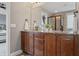 Well-lit bathroom with a granite countertop vanity, dark wood cabinetry, and a framed mirror at 10264 Normandy Way, Fishers, IN 46040
