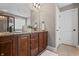 Elegant bathroom featuring granite counters, wood cabinets, a mirror, and a tile floor at 10264 Normandy Way, Fishers, IN 46040