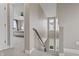 Bright hallway featuring carpeted stairs, neutral walls, and views into a carpeted bedroom with a ceiling fan at 10264 Normandy Way, Fishers, IN 46040