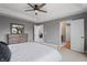 Well-lit main bedroom with a ceiling fan, dresser, large bed and an open doorway to the living room at 10264 Normandy Way, Fishers, IN 46040