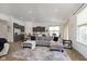 Open-concept living area with a large gray sofa, modern decor, and seamless kitchen access at 1030 Macoun Dr, Westfield, IN 46074