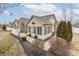 A home's exterior shows an abundance of windows, manicured shrubbery, and a partial white fence at 10329 Gateway Dr, Indianapolis, IN 46234