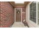 Close up view of a brown front door surrounded by a red brick exterior wall at 10329 Gateway Dr, Indianapolis, IN 46234