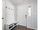 Bright entryway with white door, side window panel, a shoe bench with storage, and coat hooks on light grey walls at 10373 Cerulean Dr, Noblesville, IN 46060