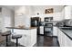 Well-lit kitchen with white cabinetry, black appliances, a center island with seating, and stylish backsplash at 10373 Cerulean Dr, Noblesville, IN 46060