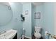 Powder room with blue walls, hardwood floors, and modern sink and mirror at 10613 Glenayr Dr, Camby, IN 46113