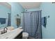 Bathroom with a blue shower curtain, single sink, and matching blue walls at 10613 Glenayr Dr, Camby, IN 46113