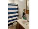 This bathroom has a blue striped shower curtain, a vanity sink, and a wooden towel rack at 1195 Hinson Rd, Martinsville, IN 46151